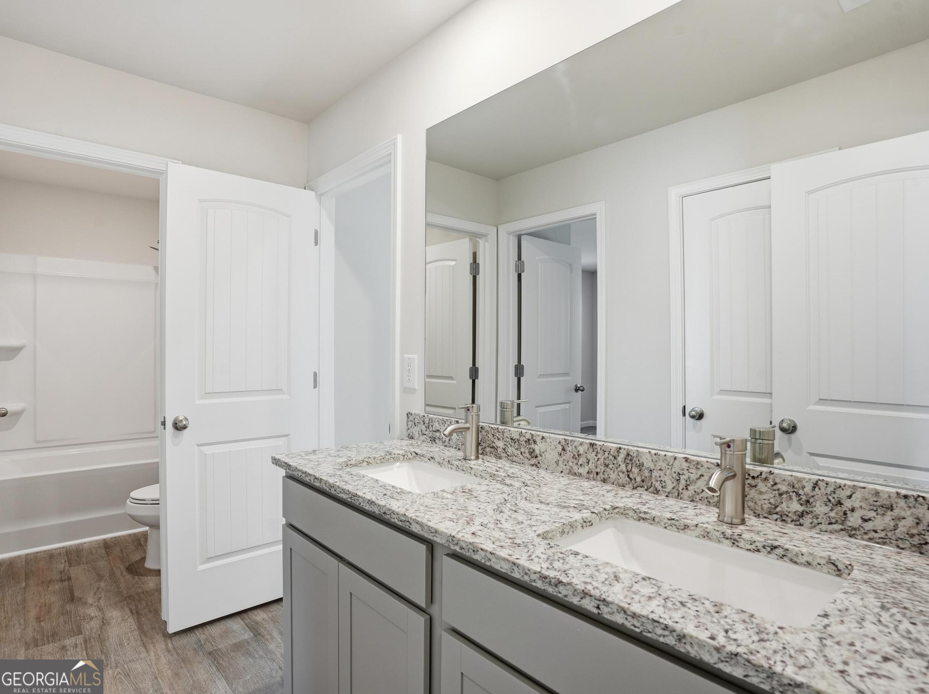 130 Post Oak Drive, Unit 130 Jackson, GA 30233 - Photo 23 of 29 a bathroom with a granite countertop sink and a mirror