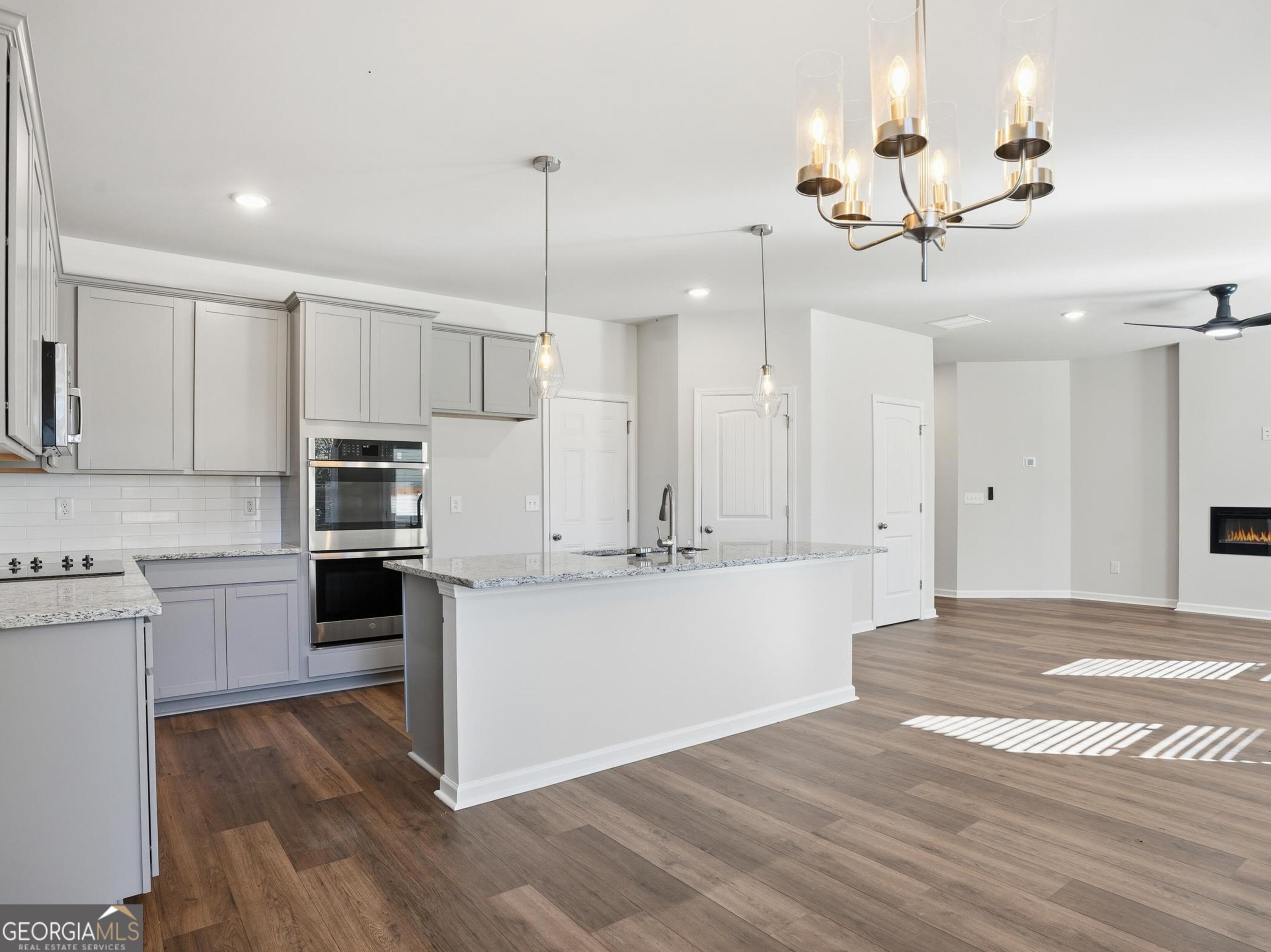 130 Post Oak Drive, Unit 130 Jackson, GA 30233 - Photo 6 of 29 a kitchen with kitchen island white cabinets and stainless steel appliances