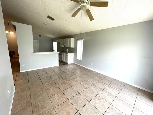 a view of a furniture and an empty room with wooden floor