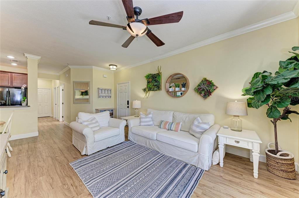 8015 Limestone Lane, Unit 15101 Sarasota, FL 34233 - Photo 11 of 46 a living room with couches painting on the wall and a potted plant