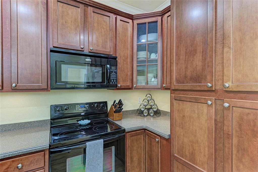 8015 Limestone Lane, Unit 15101 Sarasota, FL 34233 - Photo 17 of 46 a kitchen with granite countertop cabinets and black appliances