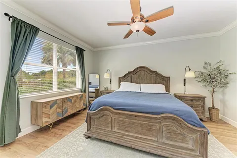 a bedroom with a bed and a large window