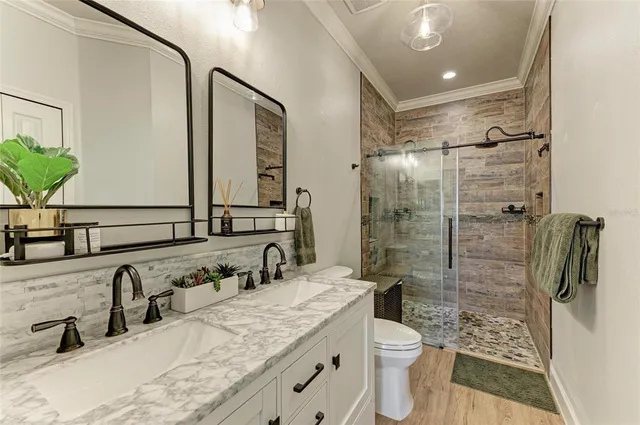 a bathroom with a double vanity sink toilet and shower