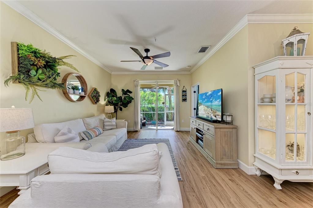 8015 Limestone Lane, Unit 15101 Sarasota, FL 34233 - Photo 9 of 46 a living room with furniture a fireplace and a flat screen tv