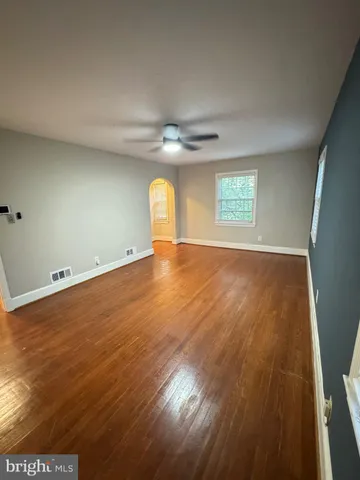 an empty room with a window and wooden floor