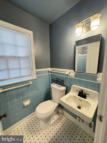 a bathroom with a sink a toilet and mirror