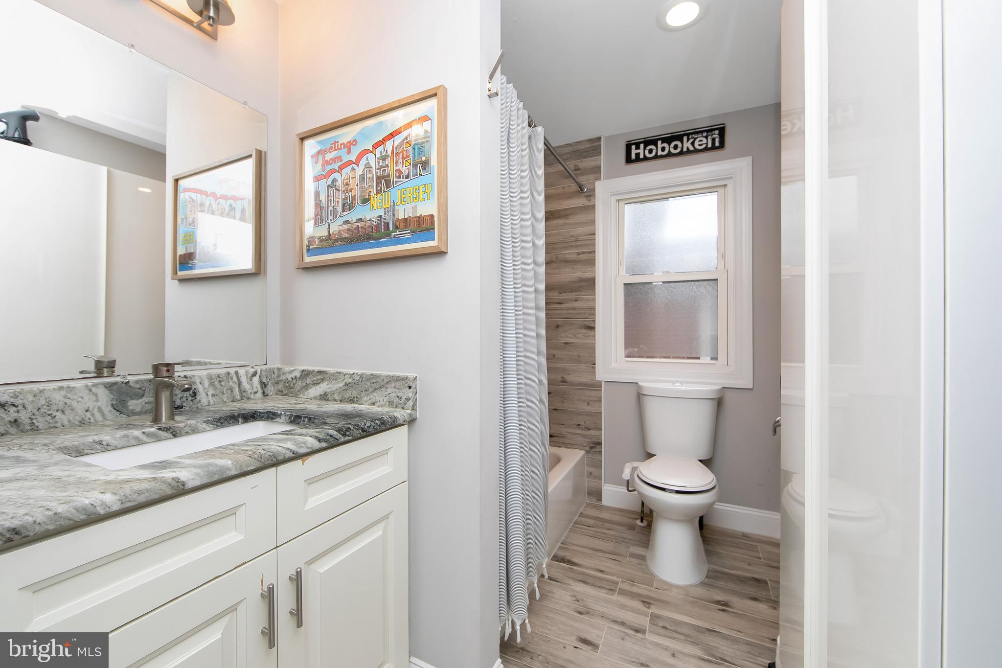 22 West 6th Avenue Runnemede, NJ 08078 - Photo 20 of 33 a bathroom with a granite countertop sink a toilet and a mirror