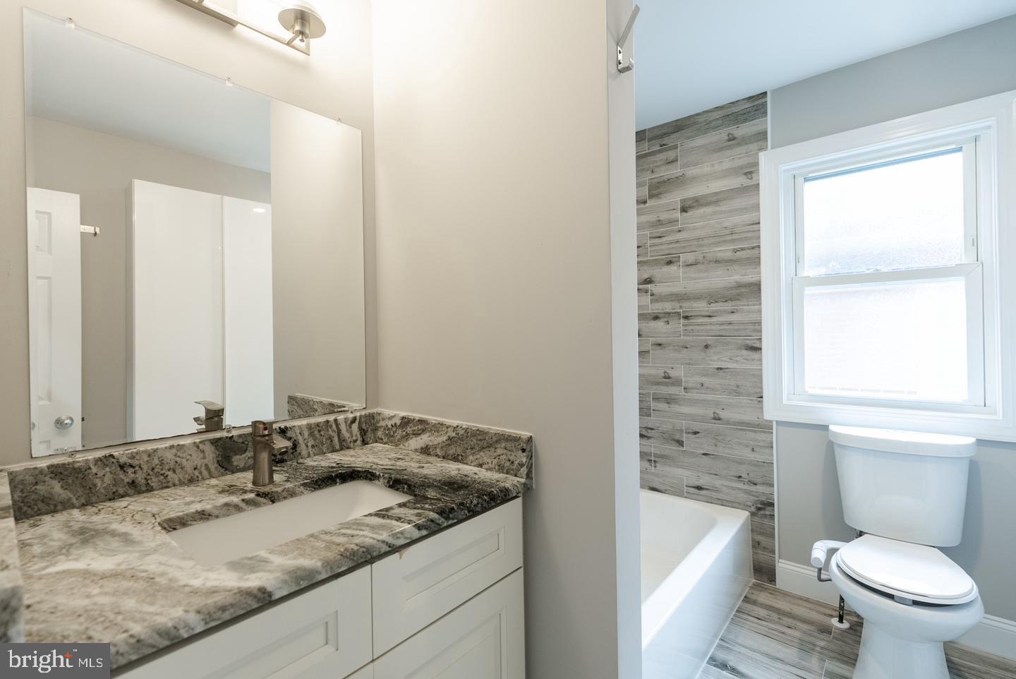 22 West 6th Avenue Runnemede, NJ 08078 - Photo 21 of 33 a bathroom with a granite countertop sink toilet and large mirror