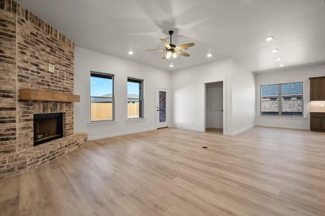 a view of an empty room with a fireplace and a window