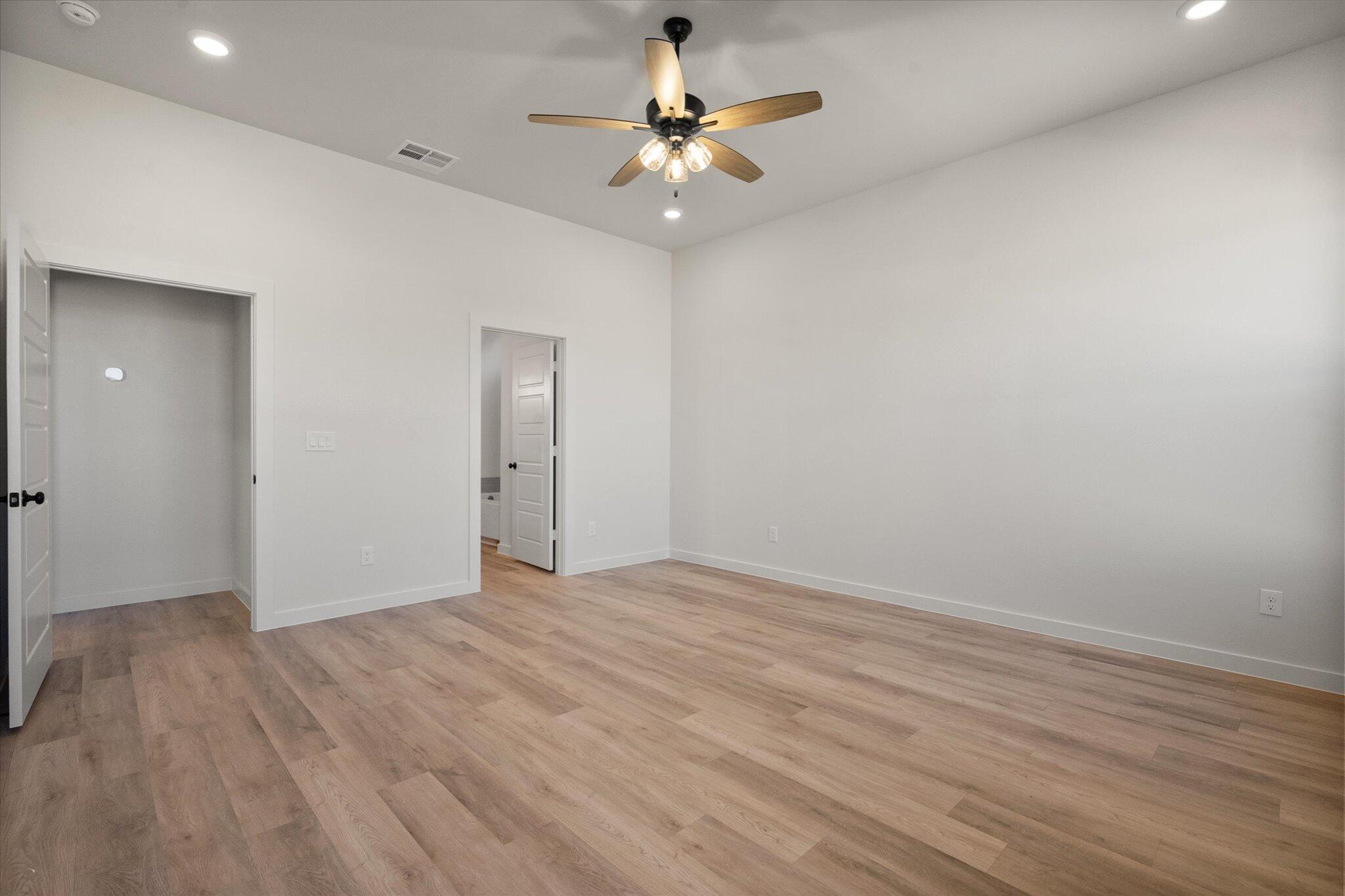 7010 16th Street Lubbock, TX 79416 - Photo 15 of 28 wooden floor in an empty room with a fan