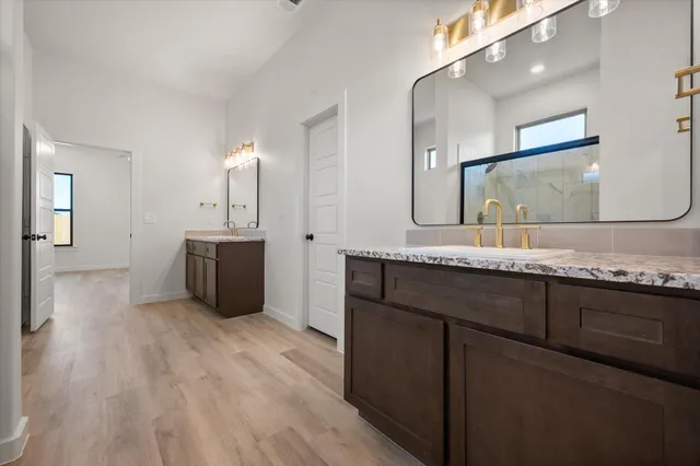 a bathroom with a sink double vanity granite and a mirror