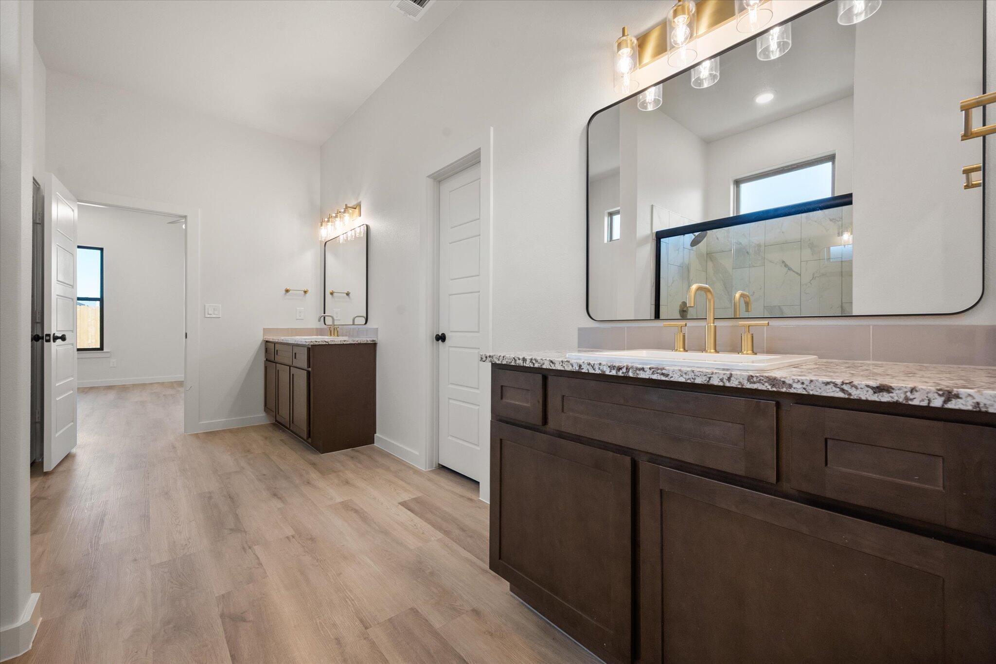 7010 16th Street Lubbock, TX 79416 - Photo 19 of 28 a bathroom with a sink double vanity granite and a mirror