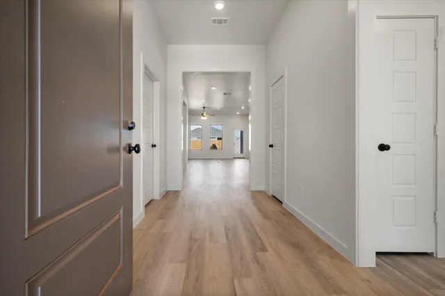 a view of a hallway with wooden floor