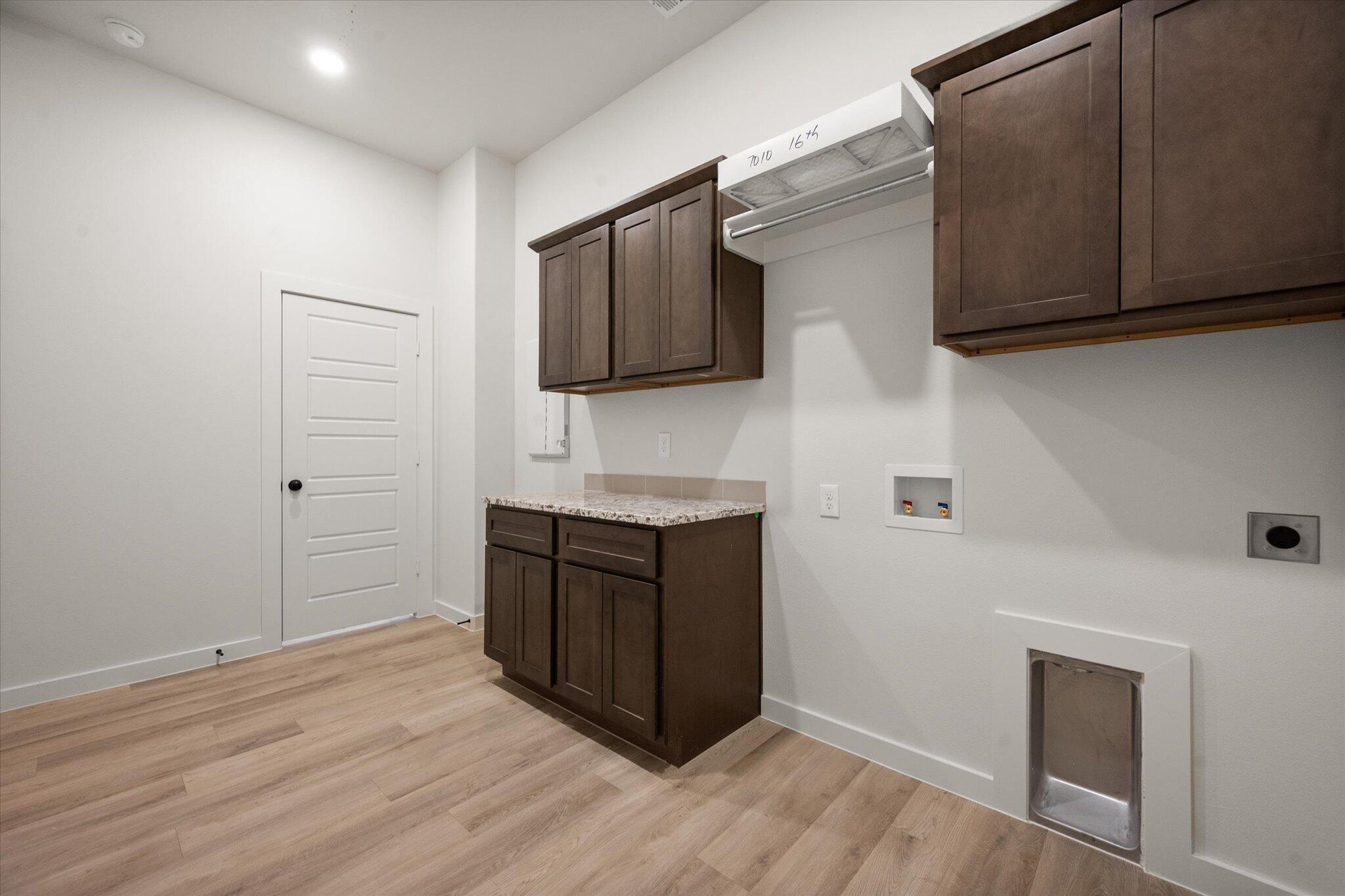 7010 16th Street Lubbock, TX 79416 - Photo 26 of 28 a kitchen with wooden cabinets and a microwave