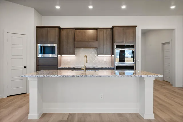 a large kitchen with granite countertop a stove and a refrigerator