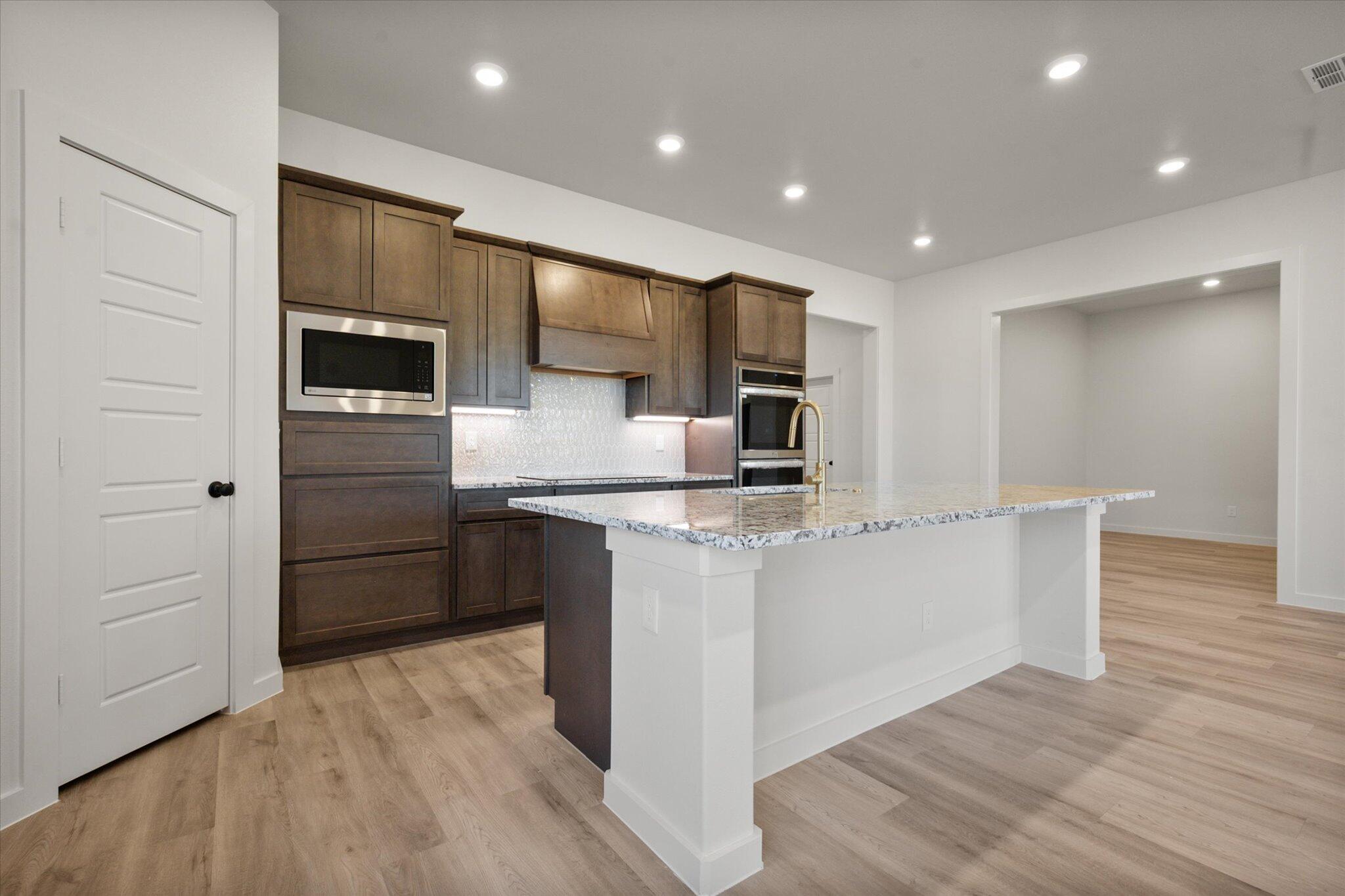 7010 16th Street Lubbock, TX 79416 - Photo 6 of 28 a kitchen with stainless steel appliances a refrigerator and a stove top oven