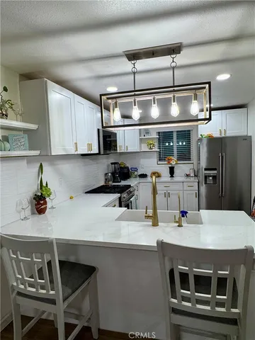 a kitchen with a sink a microwave a stove and refrigerator