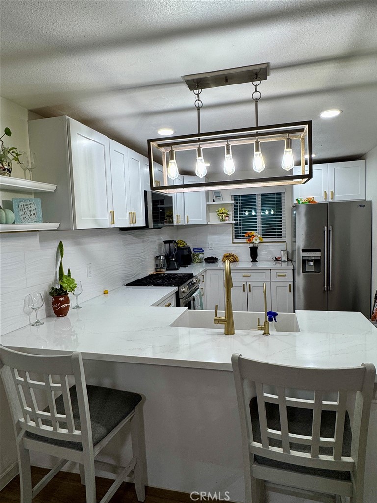 2751 Reche Canyon Road, Unit 70 Moreno Valley, CA 92555 - Photo 2 of 4 a kitchen with a sink a microwave a stove and refrigerator