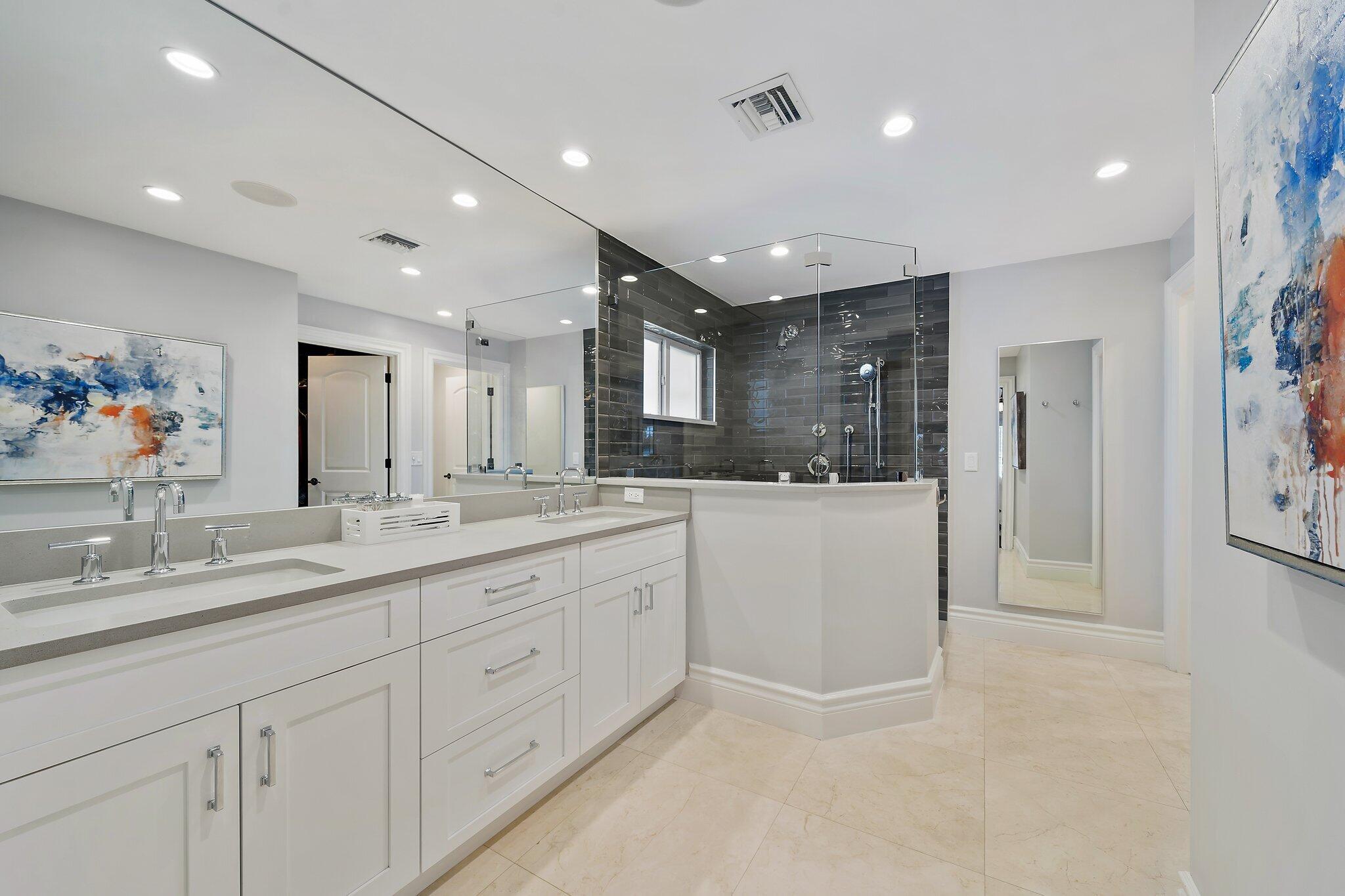 98 Golfview Drive Tequesta, FL 33469 - Photo 15 of 34 a large white bathroom with a granite countertop sink mirror and shower