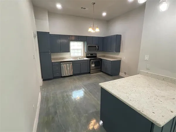 a kitchen with a sink cabinets and wooden floor
