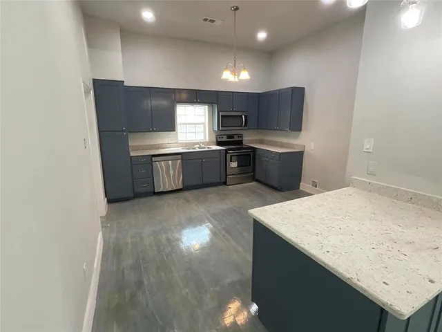 a kitchen with a sink cabinets and wooden floor