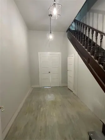 a view of an empty room with chandelier fan