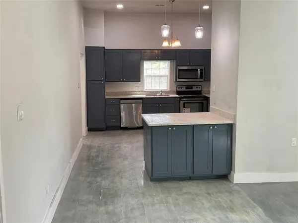 a kitchen with stainless steel appliances a refrigerator and a stove top oven