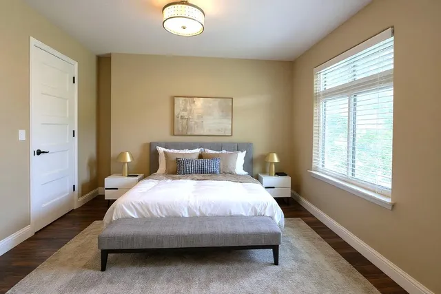 a bedroom with a bed lamp and a window