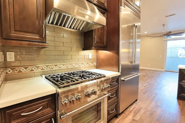 a view of kitchen with stainless steel appliances granite countertop cabinets and wooden floor