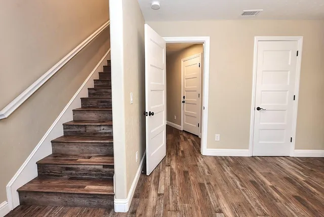 a view of a chandelier in big room with wooden floor a chandelier