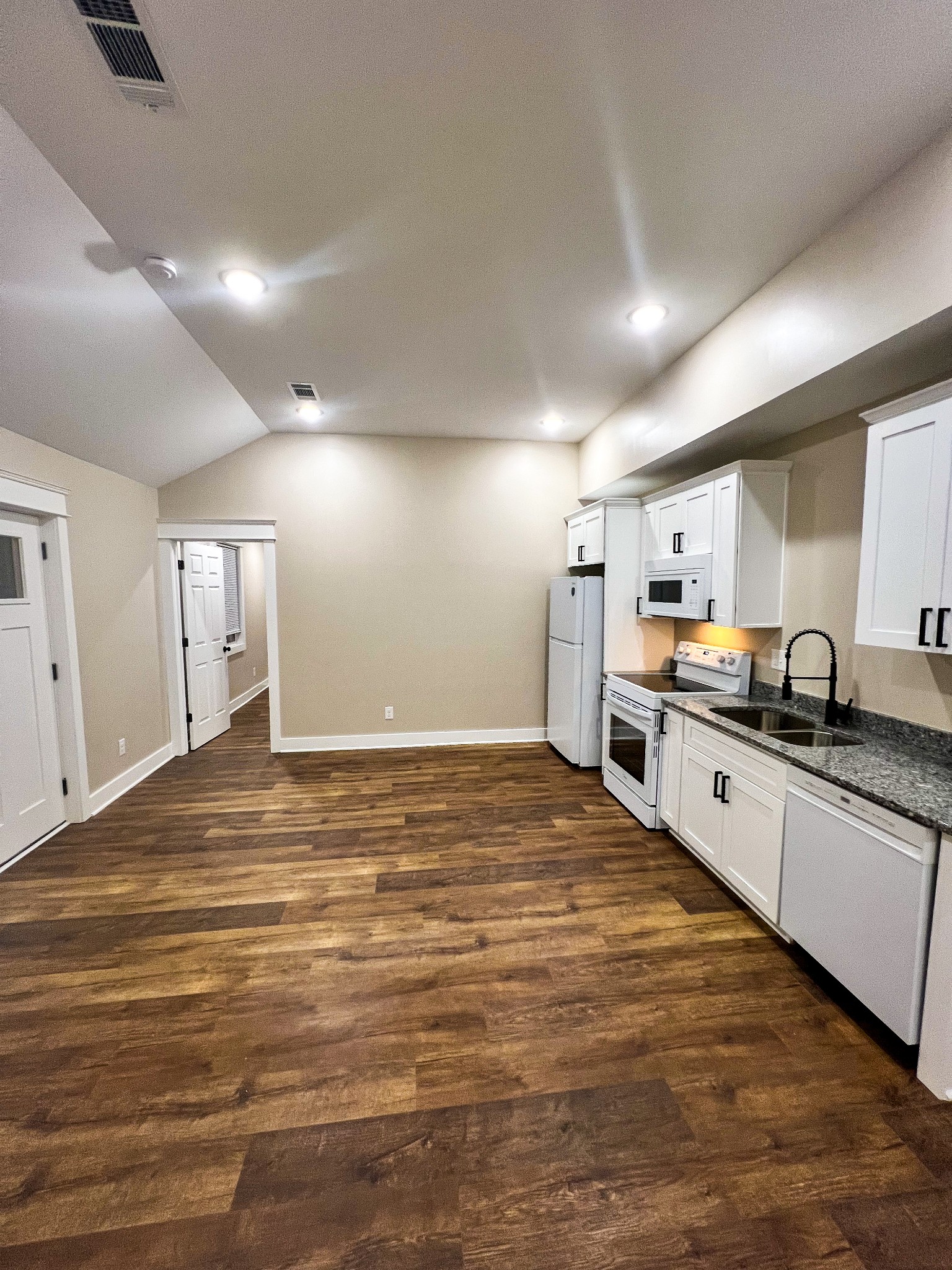 107 1st Avenue, Unit A Murfreesboro, TN 37130 - Photo 2 of 7 a large white kitchen with kitchen island a sink stainless steel appliances and cabinets