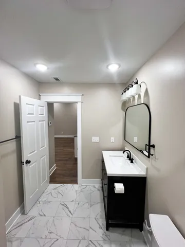 a bathroom with a sink mirror and toilet