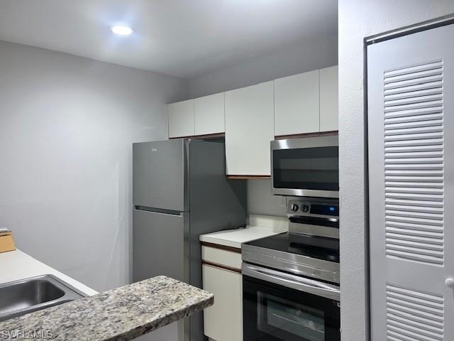 153 Santa Clara Drive, Unit 10 Naples, FL 34104 - Photo 3 of 33 a kitchen with a refrigerator stove and microwave