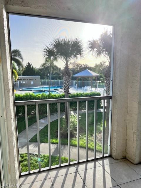 153 Santa Clara Drive, Unit 10 Naples, FL 34104 - Photo 9 of 33 a view of a balcony with a floor to ceiling window and wooden fence