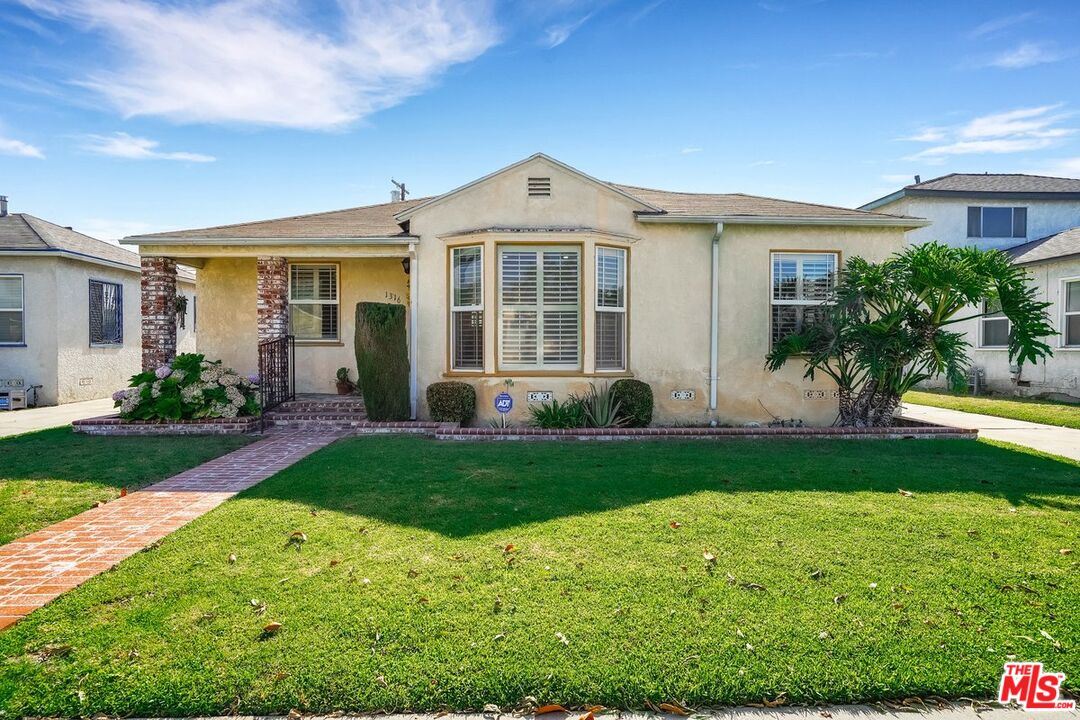 1316 South Castlegate Avenue Compton, CA 90221 - Photo 3 of 28 a front view of a house with a yard and porch