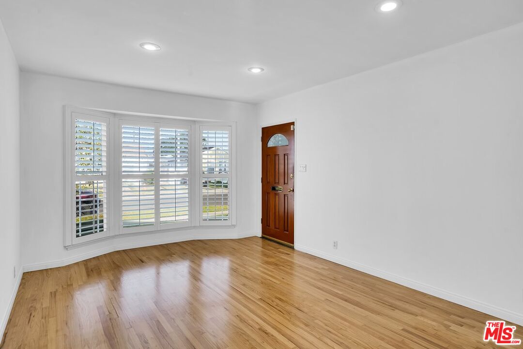 1316 South Castlegate Avenue Compton, CA 90221 - Photo 6 of 28 a view of an empty room with wooden floor and a window