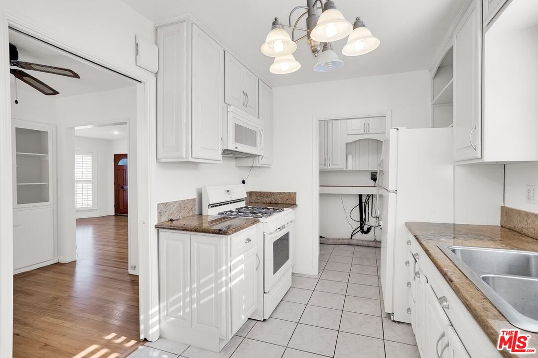 1316 South Castlegate Avenue Compton, CA 90221 - Photo 8 of 28 a kitchen with a stove cabinets and wooden floor