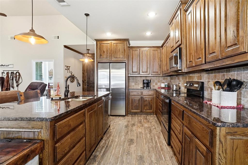 1024 Tex Lane Springtown, TX 76082 - Photo 13 of 40 a kitchen with kitchen island granite countertop lots of counter top space and stainless steel appliances