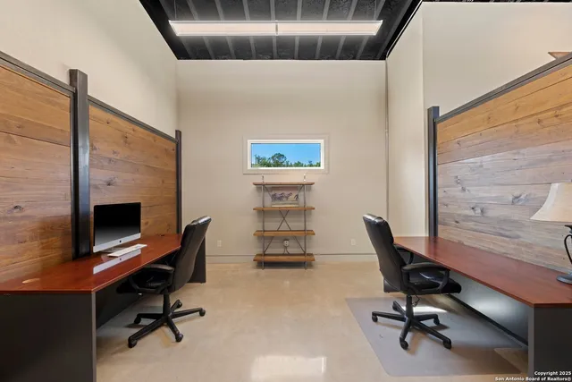 a view of a workspace with furniture and a window
