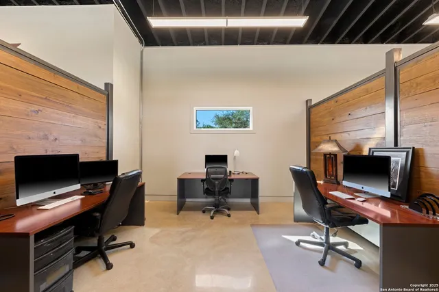 a view of a workspace with furniture and a window