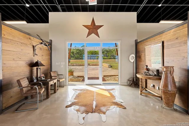 a living room with furniture a flat screen tv and floor to ceiling window