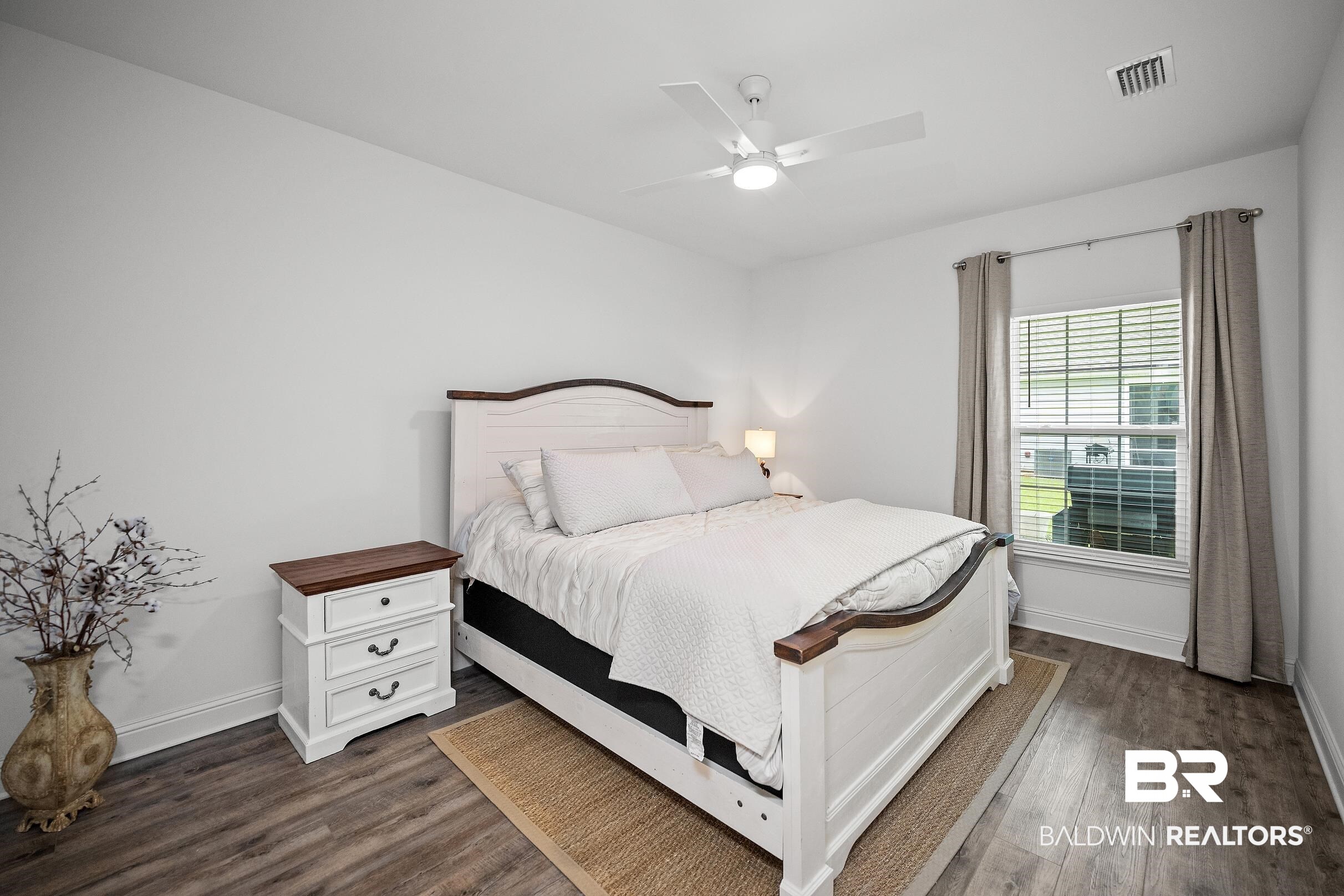 2651 South Juniper Street, Unit 2002 Foley, AL 36535 - Photo 10 of 23 Neutral white walls with crown molding, wood-finish flooring, and a ceiling fan with integrated lighting