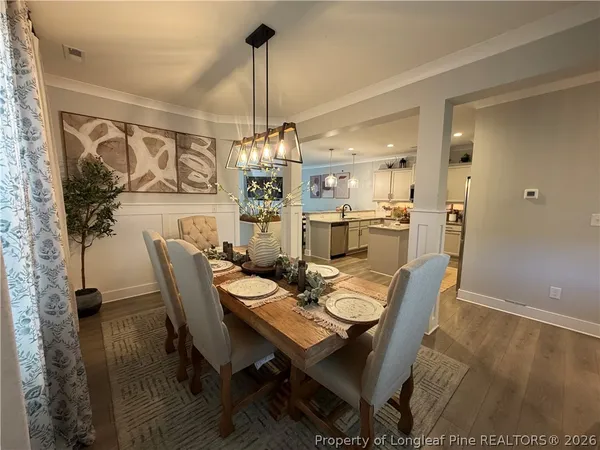 a dining room with furniture a chandelier and wooden floor