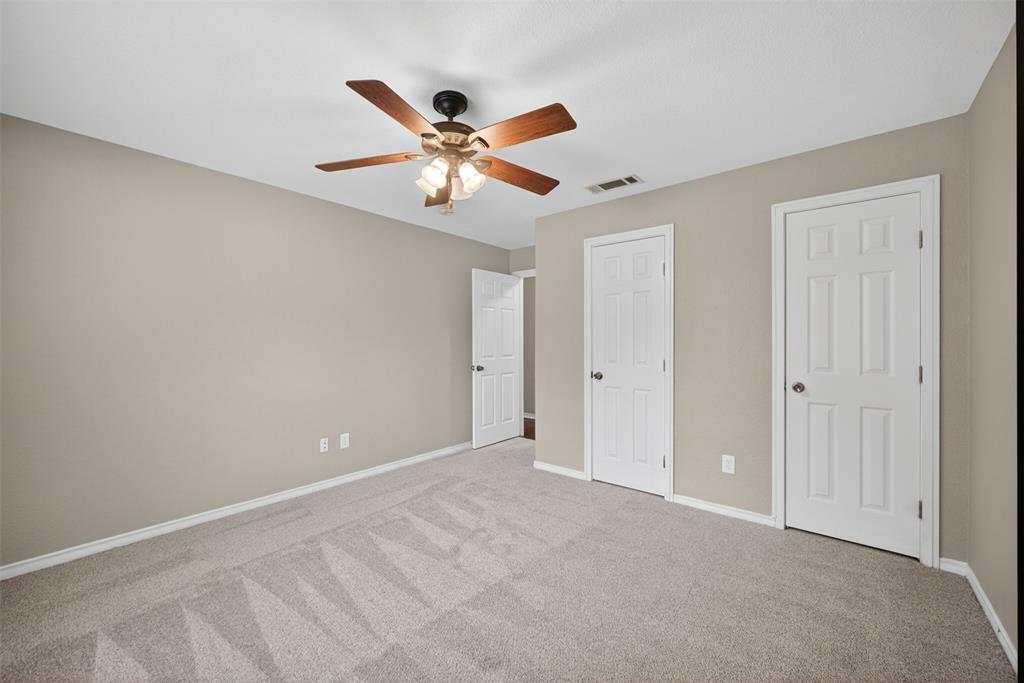 9660 Timberleaf Drive Dallas, TX 75243 - Photo 22 of 40 Neutral-toned room featuring a ceiling fan with light kit, soft gray carpet, and multiple white paneled doors