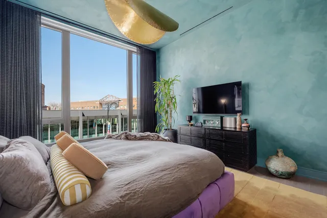 a bedroom with a bed and a flat tv screen on dresser