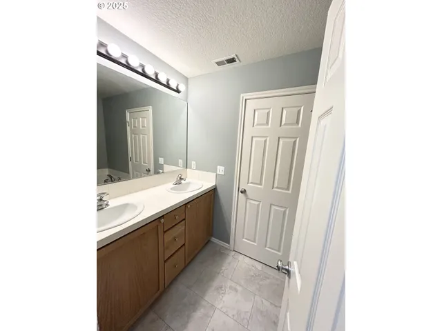 a bathroom with a double vanity sink and mirror