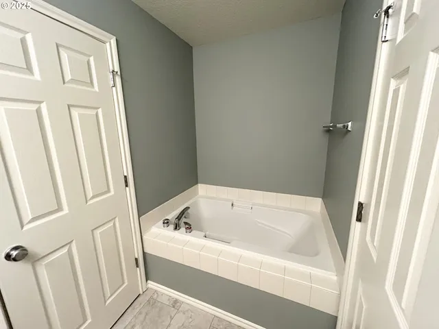 a white bath tub sitting next to a white wooden wall
