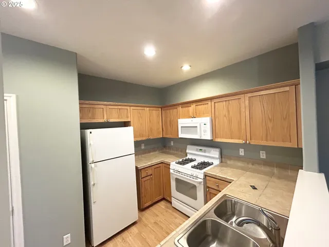 a kitchen with a refrigerator a stove a sink and a microwave