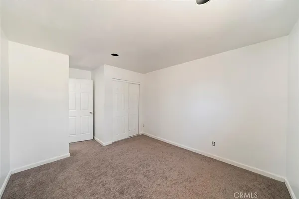 an empty room with windows and closet