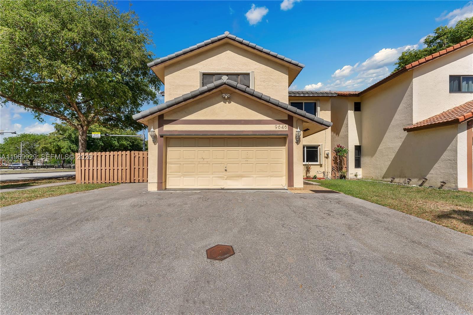 9646 Southwest 151st Avenue, Unit 1 Miami, FL 33196 - Photo 1 of 26 a front view of a house with a yard and garage